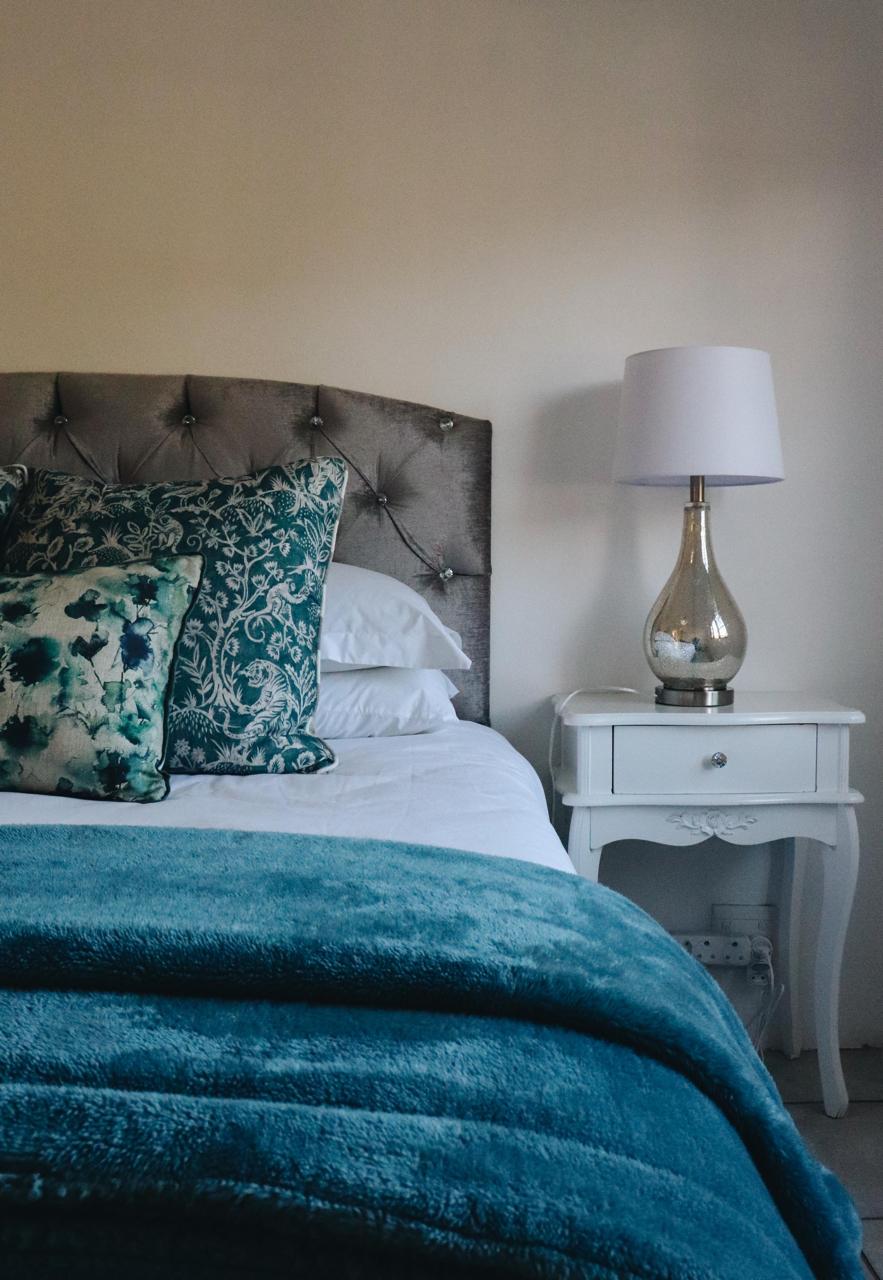 Bedroom detail with layered cushions and warm lighting at Sipreslaan
